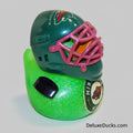 Toy hockey helmet with pink cage on a green base, featuring Minnesota Wild branding.