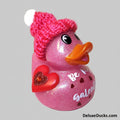 Pink glittery duck with a red heart and pink knitted hat on a white background