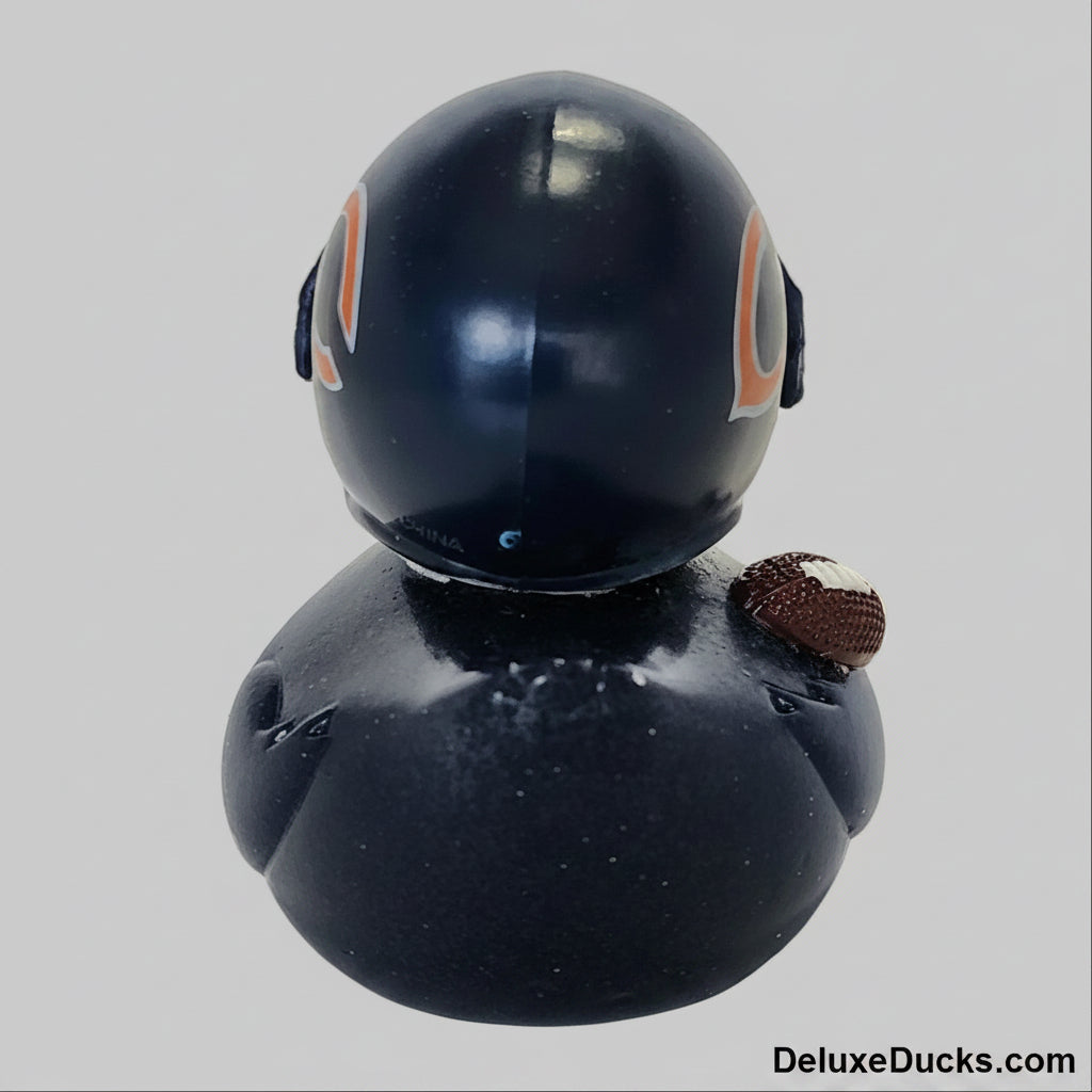 Black rubber duck with a football on a gray background