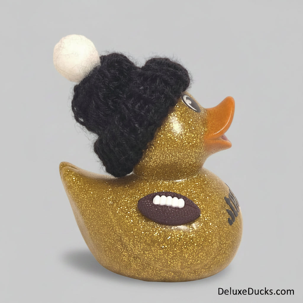 Gold glitter rubber duck wearing a black knit hat on a beige background