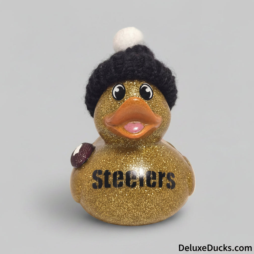 Gold glitter rubber duck wearing a black knit hat with a white pom-pom on a beige background