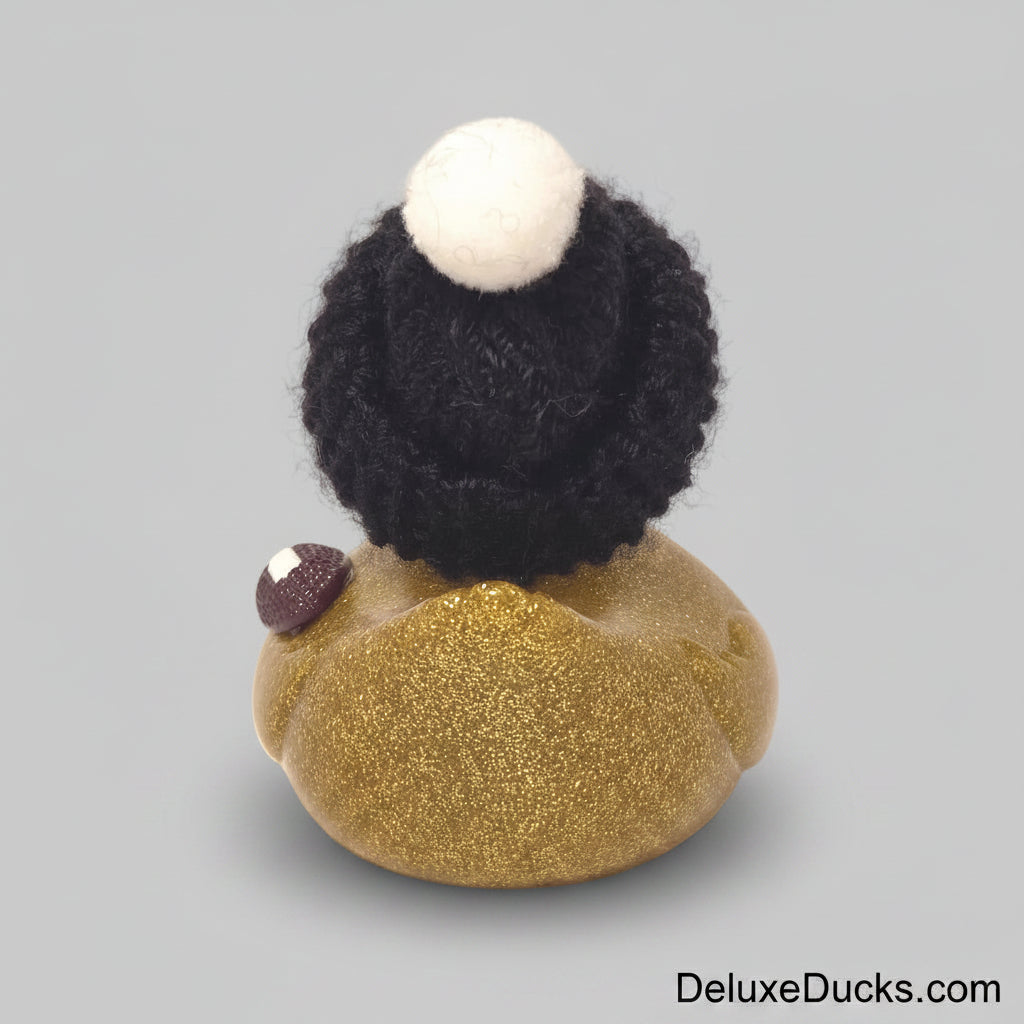 Small decorative item with a black textured top and gold base on a beige background