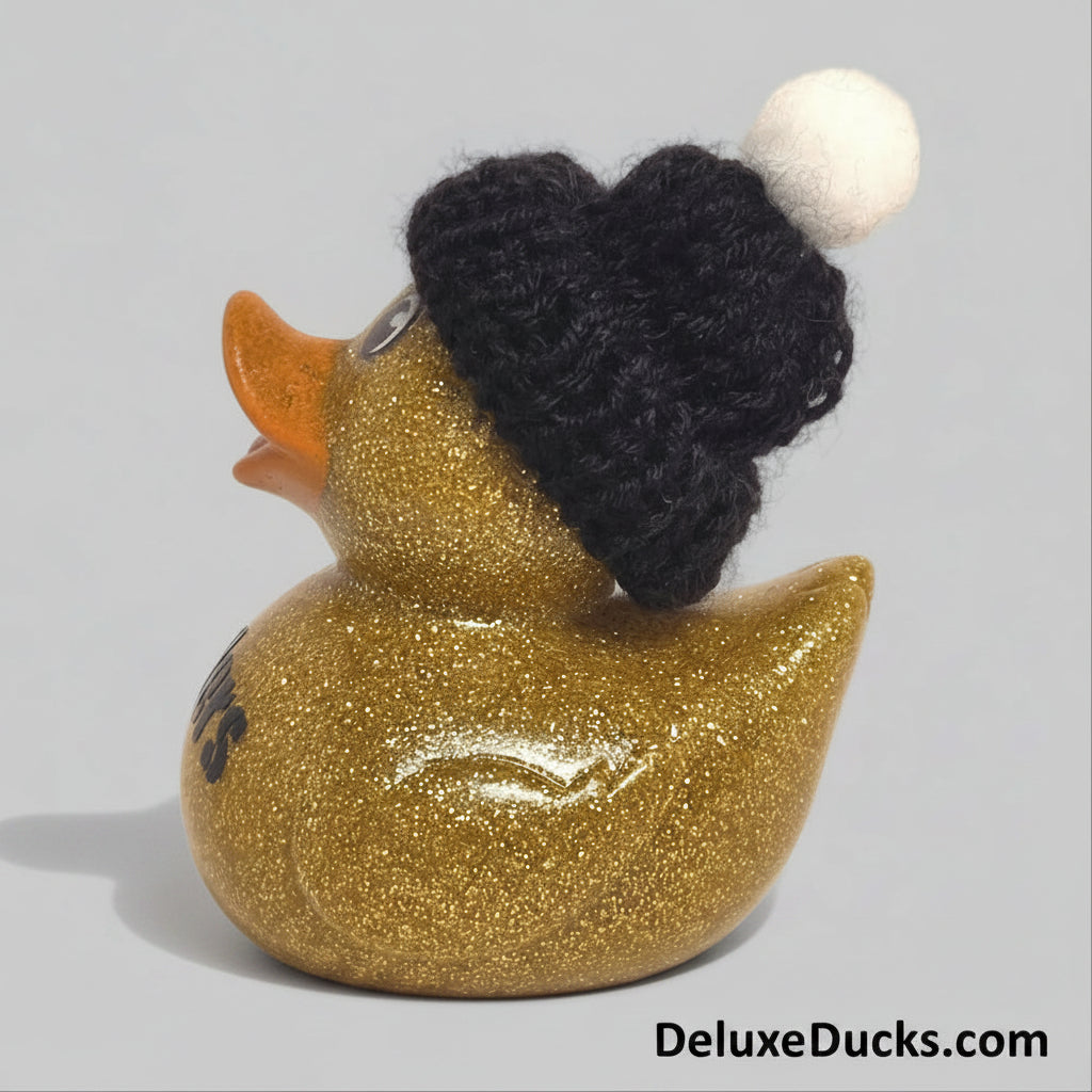 Gold glitter rubber duck wearing a black knitted hat on a beige background