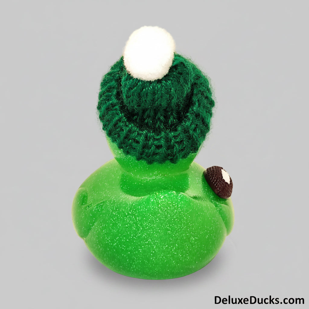 Green rubber duck with a knitted hat on a beige background