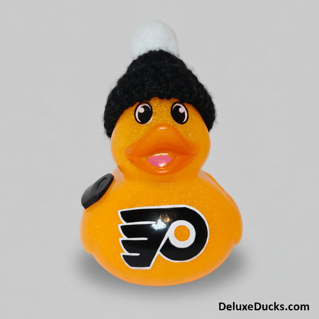 Rubber duck with a hockey puck and black beanie on a white background