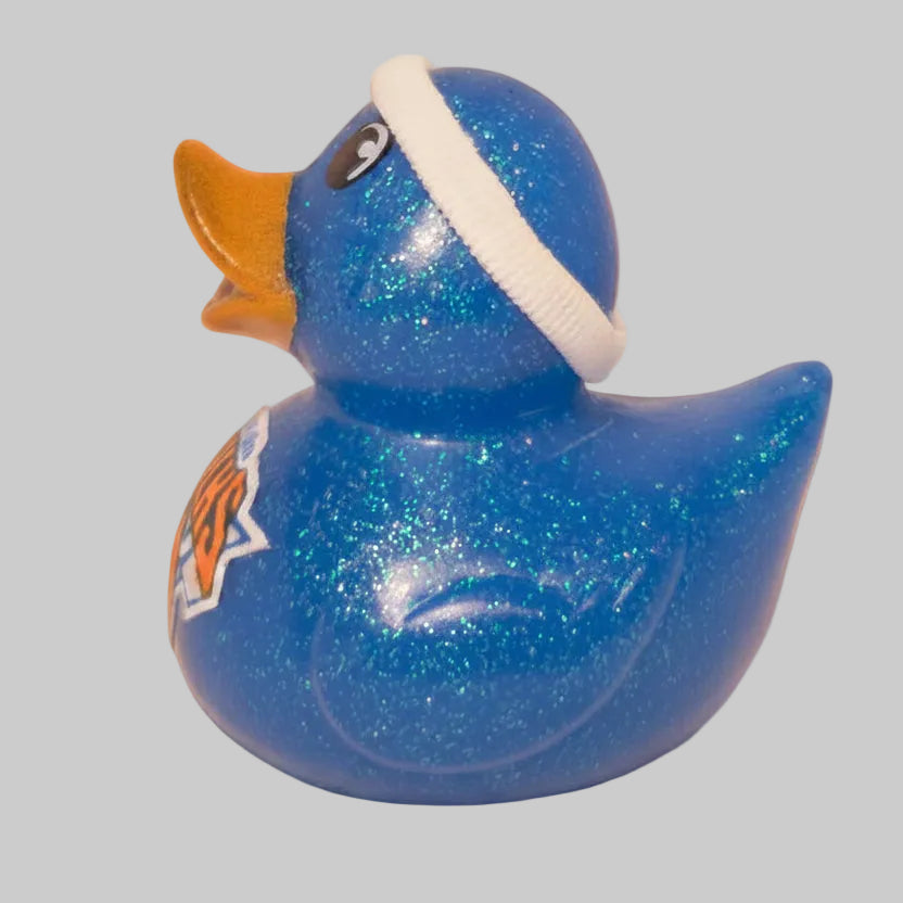 Blue glittery duck toy with a white headband on a beige background