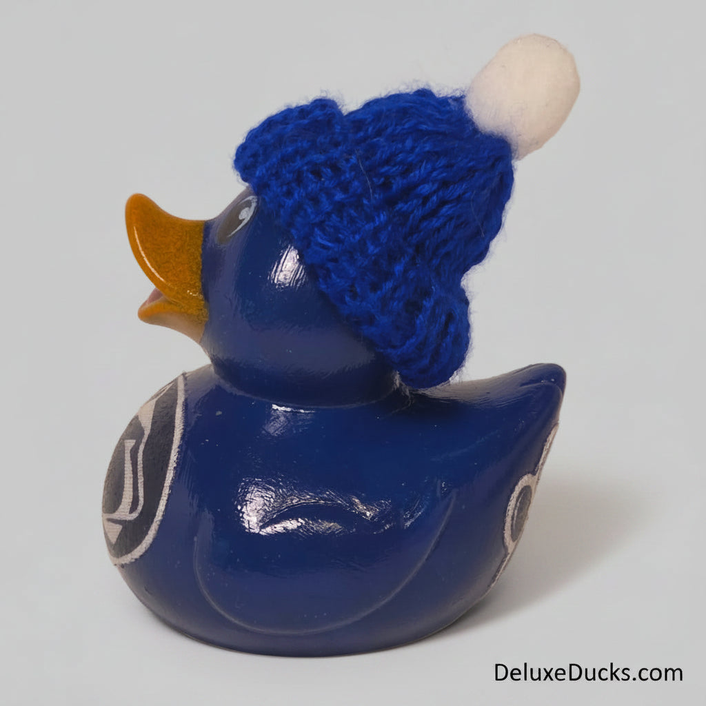 Blue rubber duck wearing a knitted blue hat on a gray background