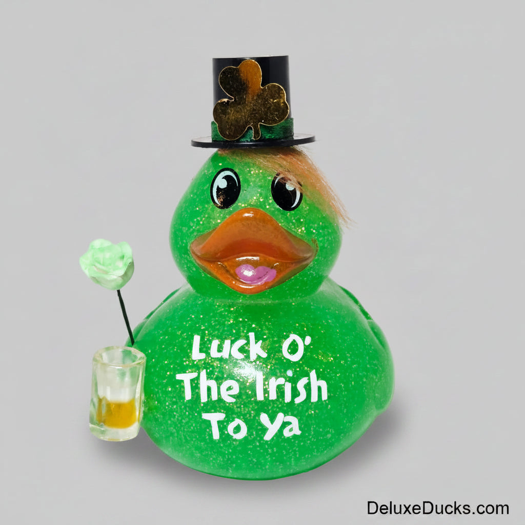 Green glittery duck figurine with a top hat and shamrock, holding a shot glass, on a white background.