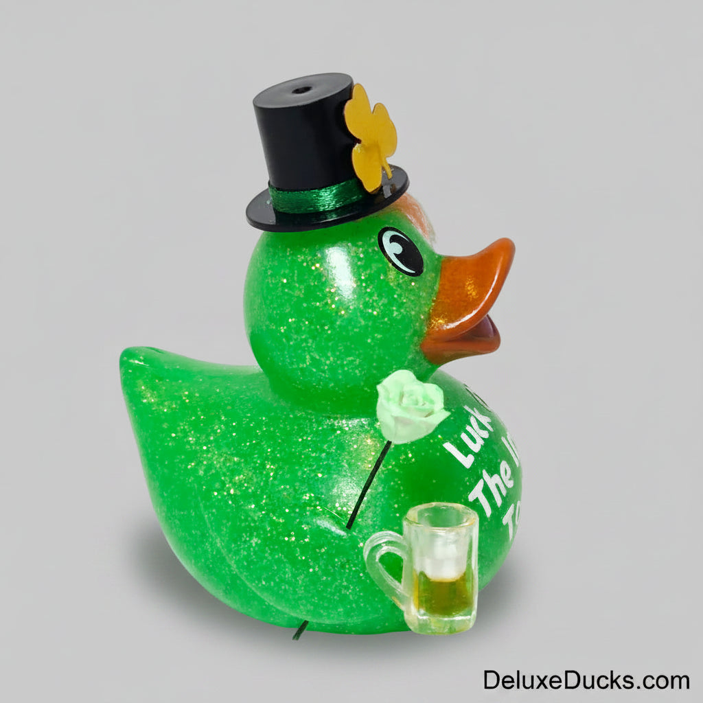 Green rubber duck with a top hat, flower, and glass of beer on a white background