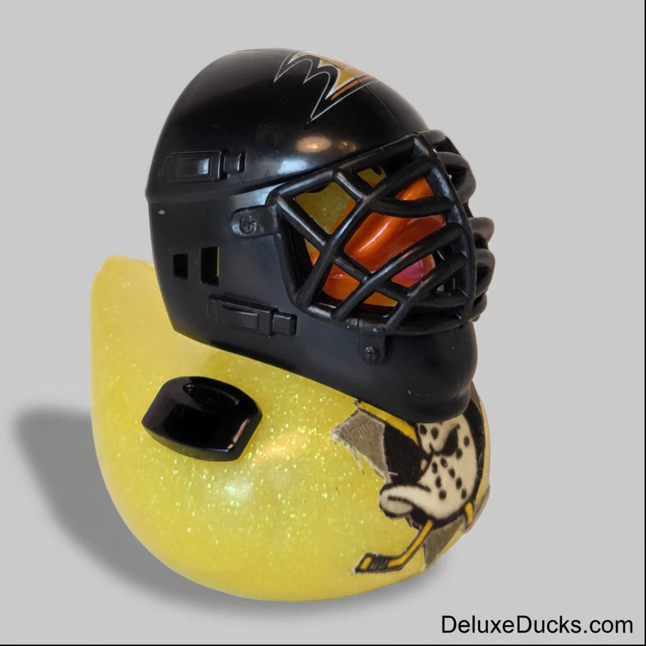 Black helmet with cage and yellow object on a light background