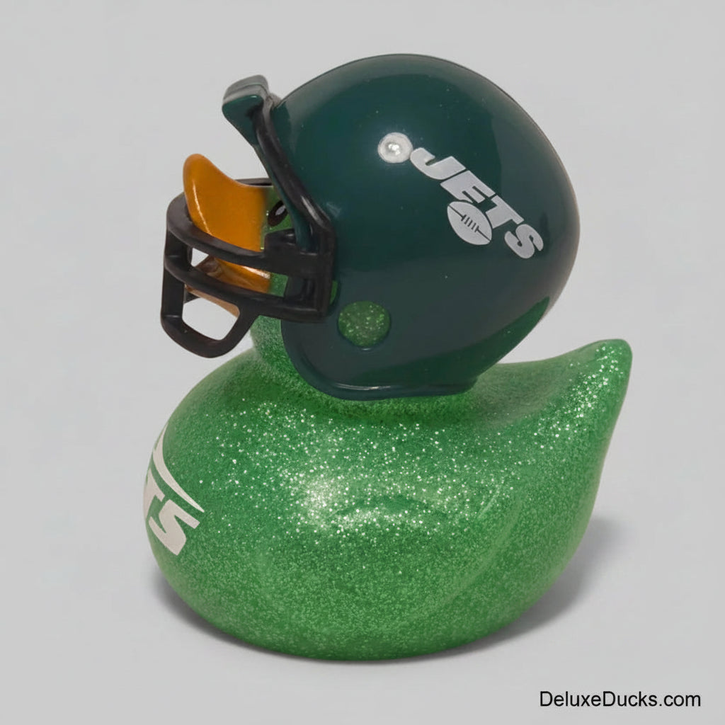 A green glitter rubber duck with a New York Jets football helmet mounted on top, photographed against a neutral gray background.