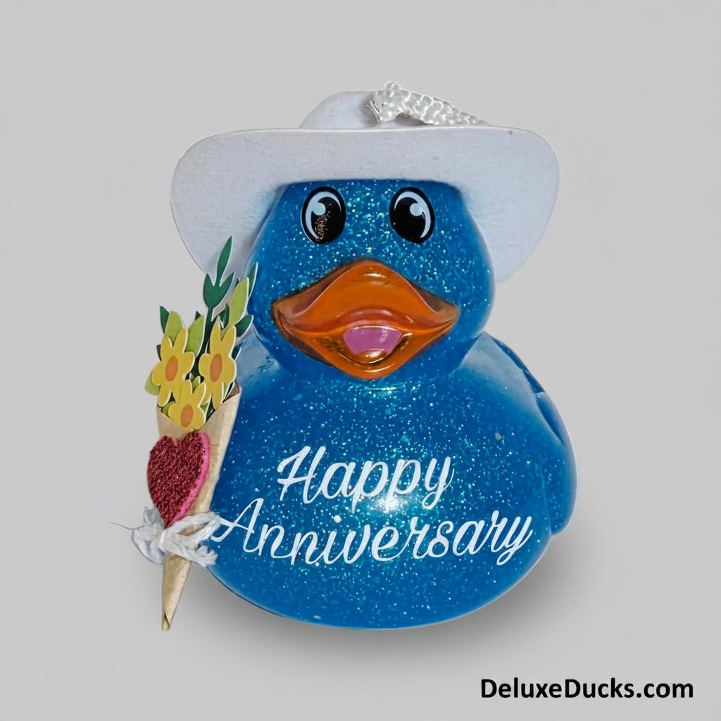 Blue glittery duck ornament with a white hat, holding a bouquet of flowers and a 'Happy Anniversary' message on a white background.