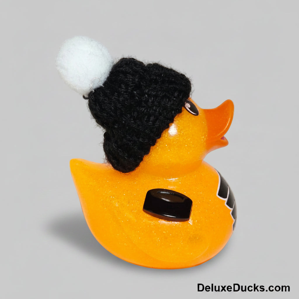 Orange rubber duck wearing a black knit hat on a light gray background